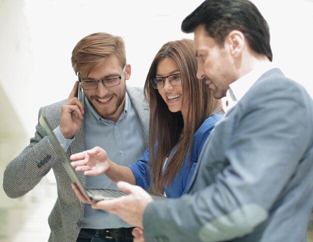 Foto cerrar empleados con una computadora portátil discutiendo nueva foto de información con espacio de copia