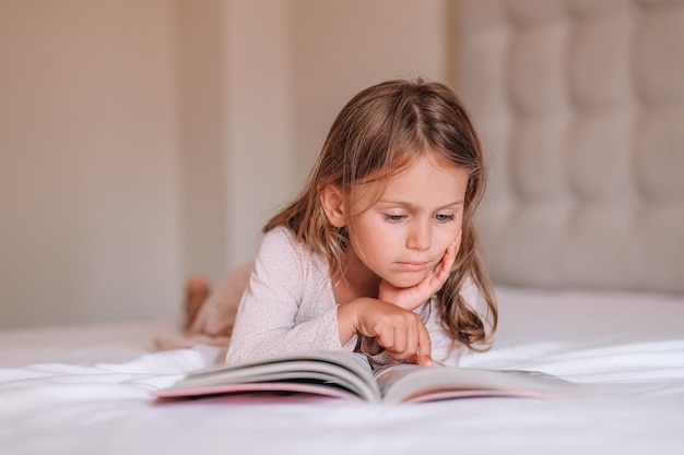 Cerrar enfocado niño niña leer libro en la camaDía internacional de la alfabetización
