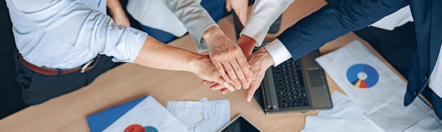 Foto cerrar el equipo de negocios con las manos juntas foto superior en la oficina moderna