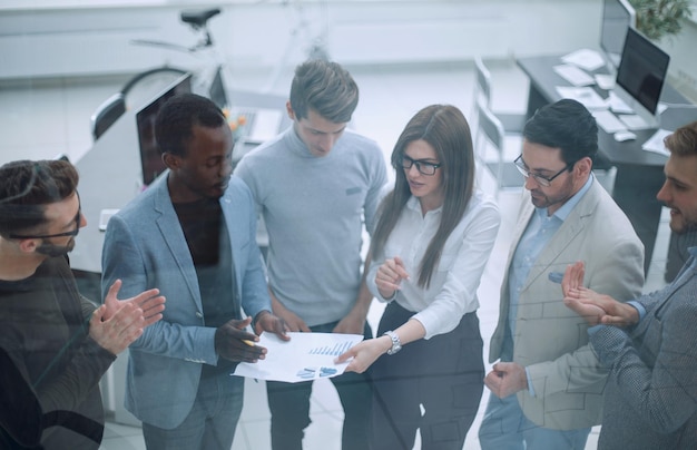 Cerrar el equipo de upbusiness discutiendo el documento de negocios el concepto de trabajo en equipo