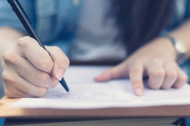 Cerrar estudiante escribiendo en papel blanco