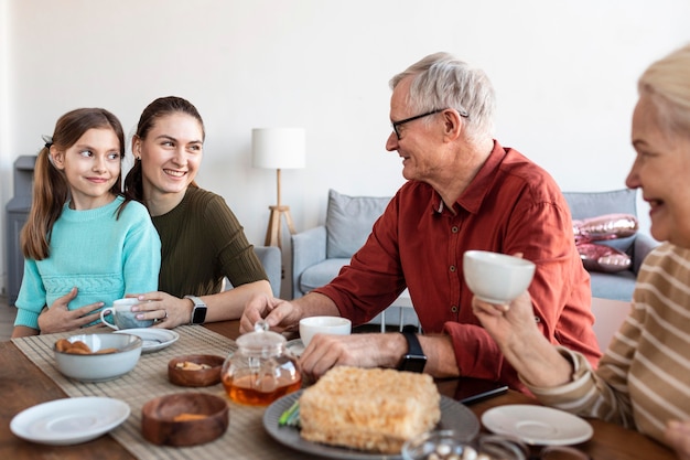 Foto cerrar familia feliz en la mesa