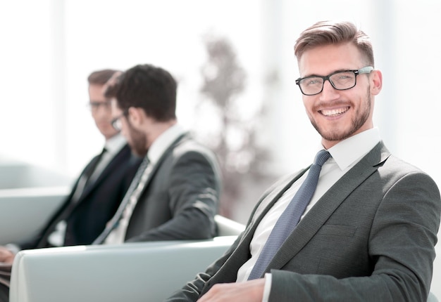 Cerrar feliz hombre de negocios sentado en la oficina moderna