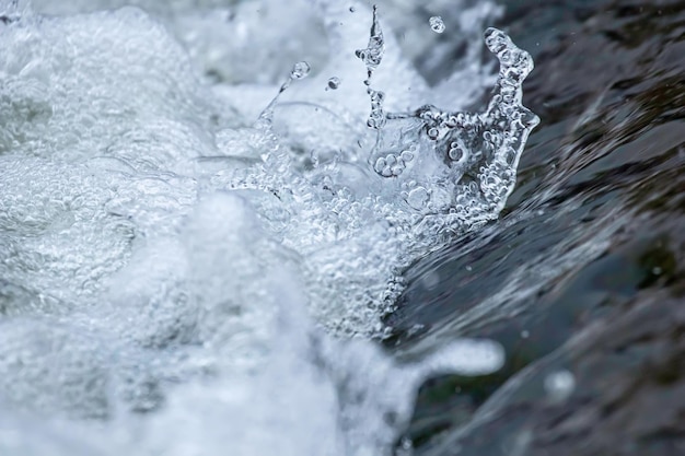 Cerrar el flujo de agua, pequeña cascada, salpicaduras de agua, burbujas de agua, agua que fluye