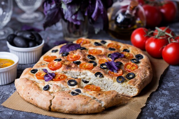 Cerrar en focaccia con tomate, aceitunas negras y albahaca