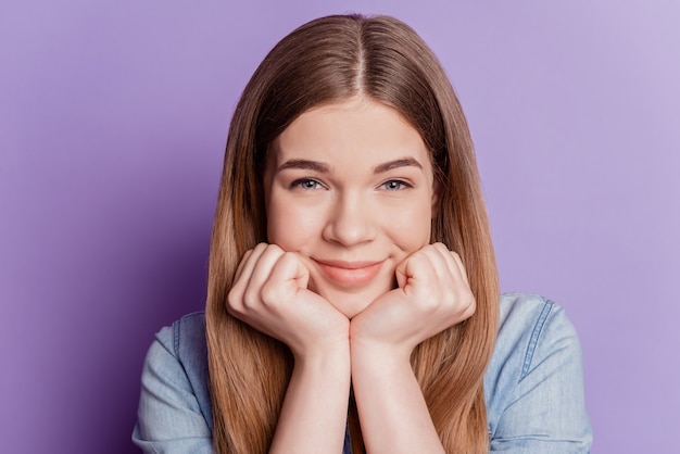 Cerrar foto de cara de manos de niña adorable adorable sobre fondo violeta