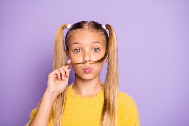 Cerrar foto de cómic divertido de niño inconformista funky hacer bigote falso con su corte de pelo con labios fruncidos y usar suéter amarillo aislado sobre pared de color violeta