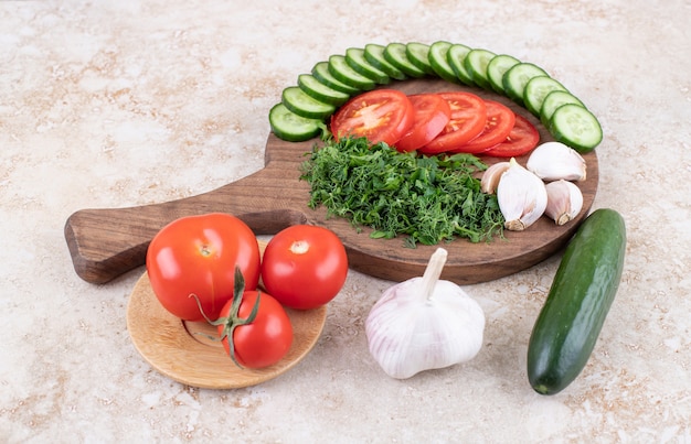 Cerrar foto del montón de verduras en rodajas en la tabla de cortar de madera