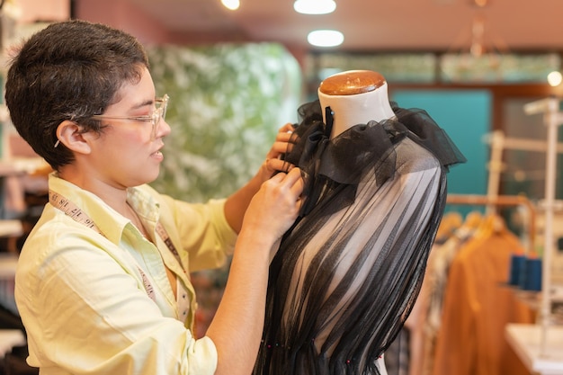 Cerrar foto de una mujer arreglando un vestido en un taller