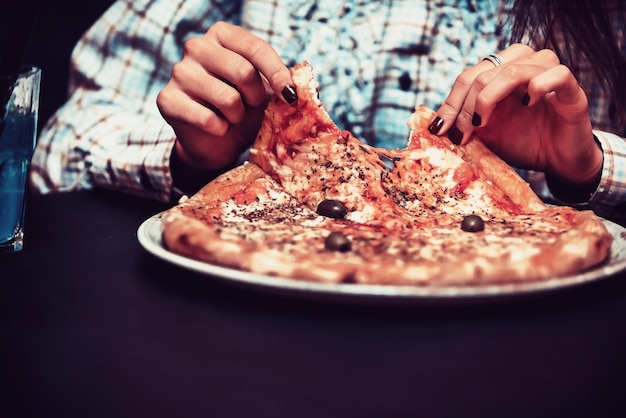 Foto cerrar foto de una mujer de negocios comiendo pizza en un descanso para almorzar. enfoque selectivo. foto de alta calidad