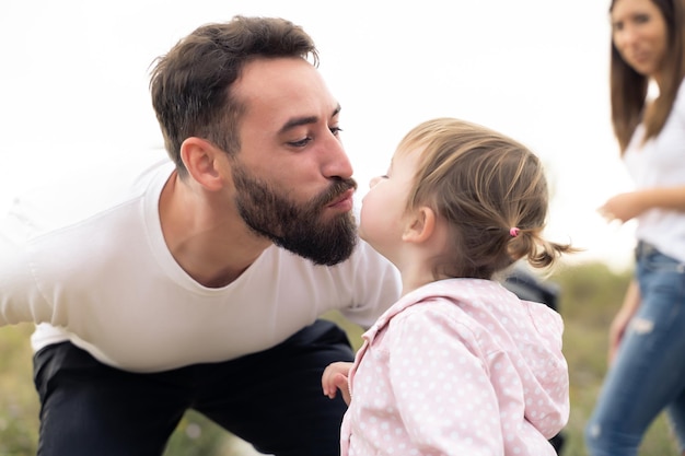 Cerrar foto de un padre besando a su hija al aire libre