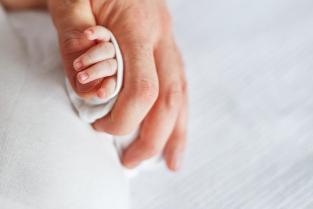 Cerrar foto de padre sosteniendo la mano del bebé recién nacido