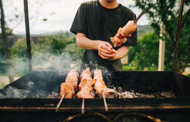 Cerrar foto del proceso de asar brochetas en brochetas a la parrilla