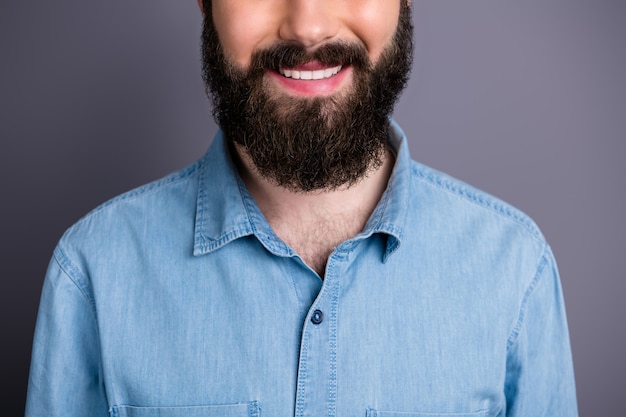 Cerrar foto recortada de sonrisa positiva de estudiante disfrutar del cuidado del cabello procedimiento de salón de spa tratamiento médico con dientes encantador concepto de chico sano usar camisa de jeans de mezclilla aislado pared de color gris