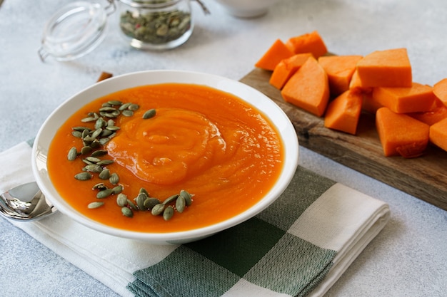 Cerrar foto de sopa de calabaza hecha puré con semillas de calabaza en la mesa