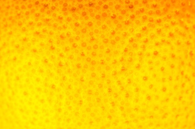 Foto cerrar una foto de la textura de la cáscara de pomelo. fondo de frutas maduras exóticas, visión macro. concepto de problema de piel humana, acné y celulitis. fondo de pantalla de naturaleza hermosa.