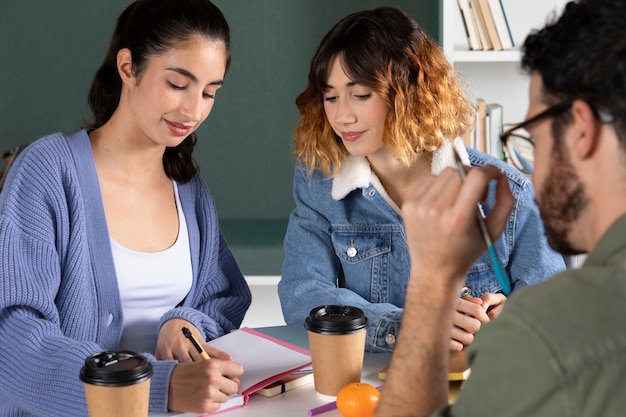 Foto cerrar gente estudiando con café