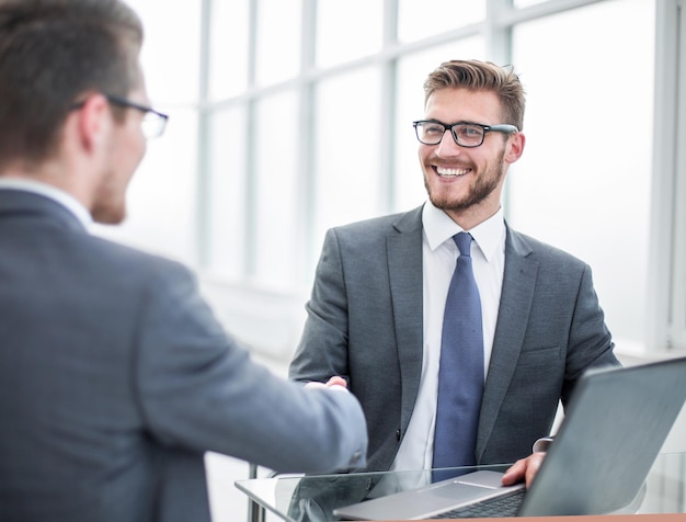 Cerrar gente de negocios sonriente dándose la mano en la oficina