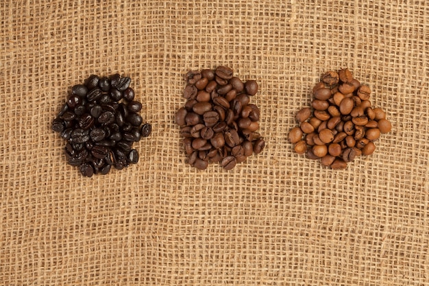 Foto cerrar en granos de café sobre fondo de arpillera
