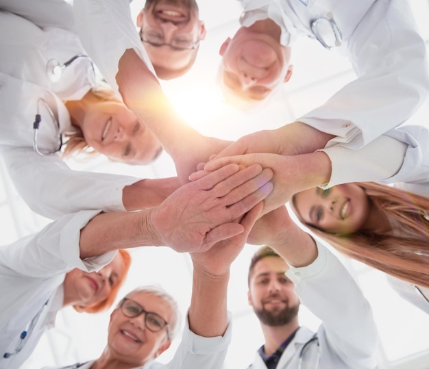 Cerrar un grupo de diferentes médicos poniendo sus manos juntas