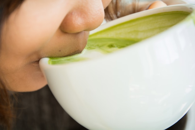 Foto cerrar hermosa chica beber té verde o café en café