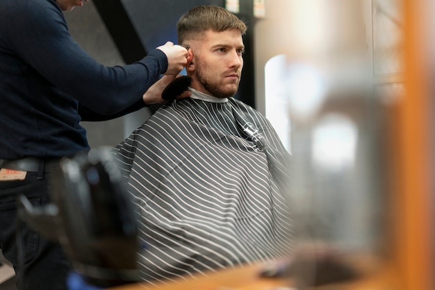 Cerrar hombre cortándose el pelo