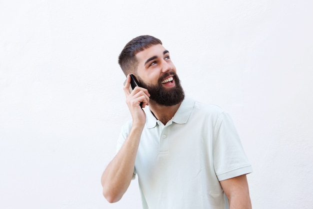 Cerrar hombre feliz con barba hablando por teléfono móvil