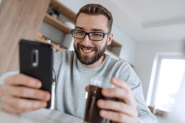 Cerrar hombre leyendo correos electrónicos durante el desayuno