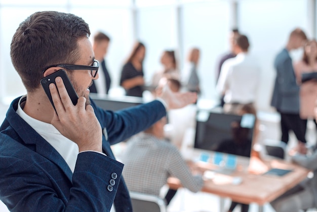 Cerrar hombre de negocios sonriente hablando en su teléfono inteligente