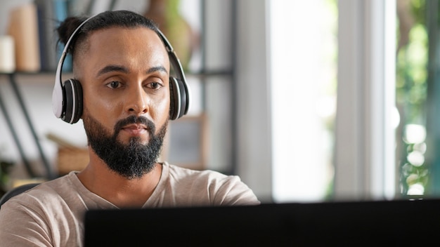 Cerrar hombre trabajando con auriculares