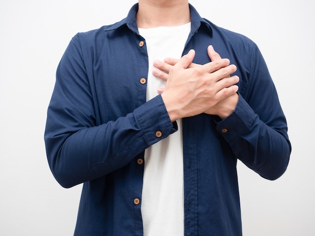 Cerrar el hombre unir sus manos toque su corazón para un tiro de cosecha agradecido