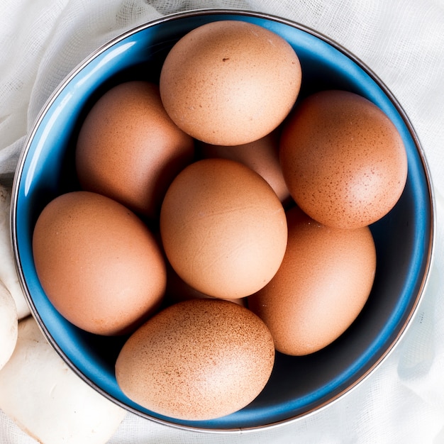 Foto cerrar huevos marrones y champiñones