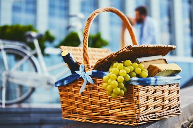 Foto cerrar imagen de cesta de picnic llena de frutas, pan y vino.
