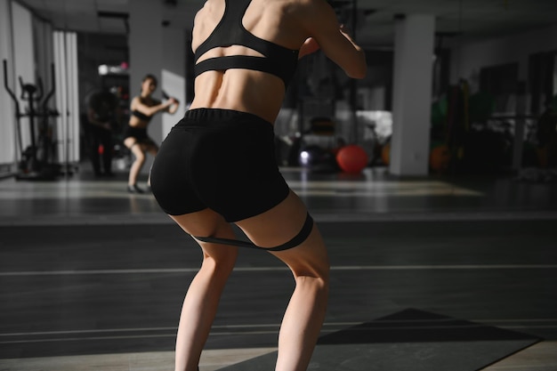 Foto cerrar imagen de mujer atractiva en forma en el gimnasio
