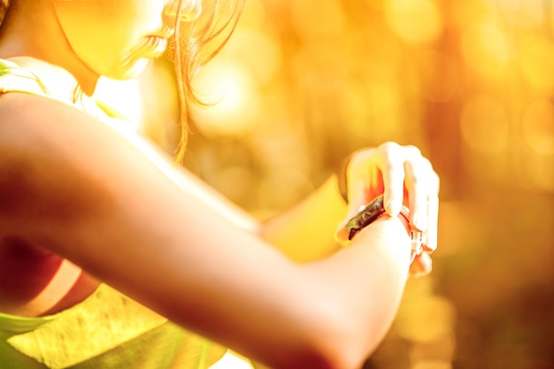 Cerrar imagen de mujer joven comprobando el tiempo