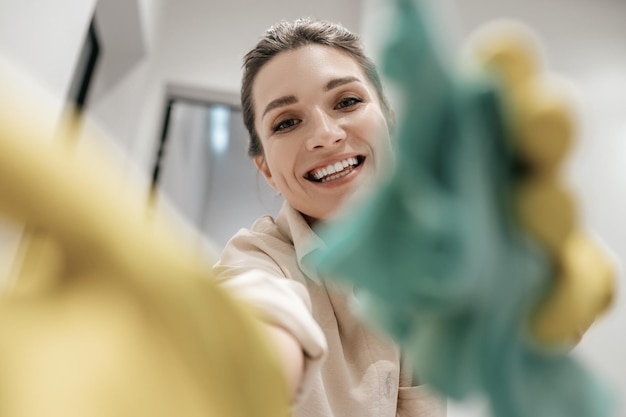 Cerrar imagen de una mujer sonriente en guantes amarillos