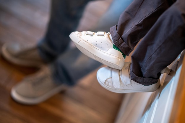 Cerrar imagen de piernas de niños en zapatillas blancas