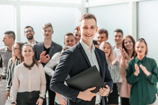 Cerrar joven gerente de proyecto de pie frente al grupo de trabajo