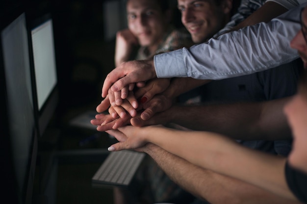 Foto cerrar jóvenes oficinistas activos mantienen sus manos juntas el concepto de unidad