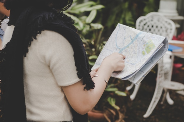 Cerrar jóvenes turistas sosteniendo y mirando en el mapa