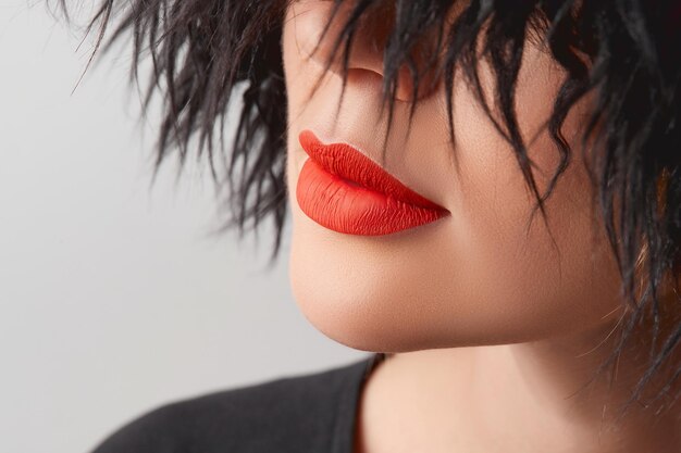 Cerrar labios regordetes femeninos con lápiz labial rojo mate belleza moda retrato cuidado personal y maquillaje