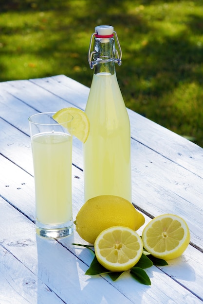 Cerrar en limonada en botella alta y limones