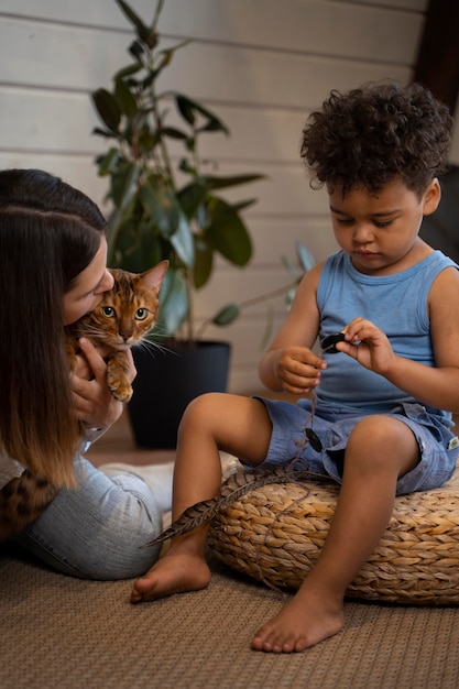 Cerrar madre, niño y gato en el interior