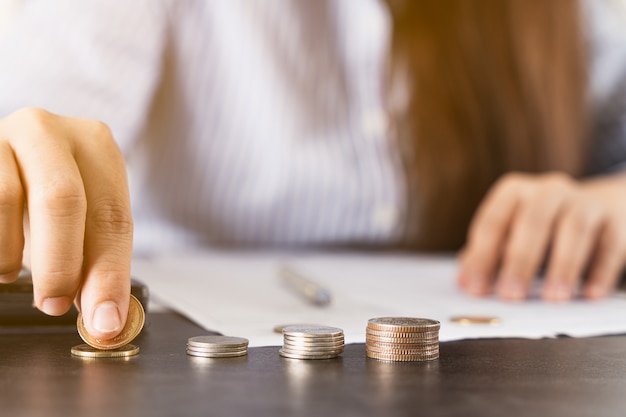 Cerrar a mano arreglando monedas en la oficina de escritorio