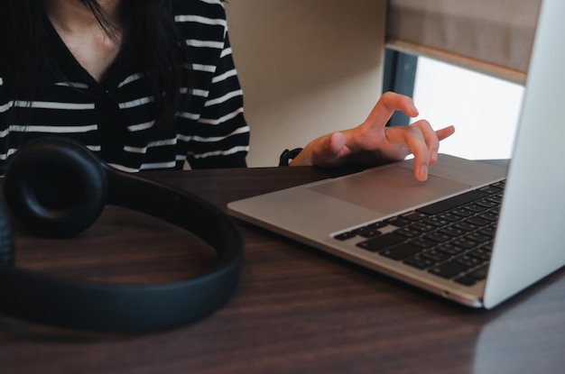 Cerrar mano chica escribiendo teclado ordenador portátil red digital en línea comunicación internet en la mesa