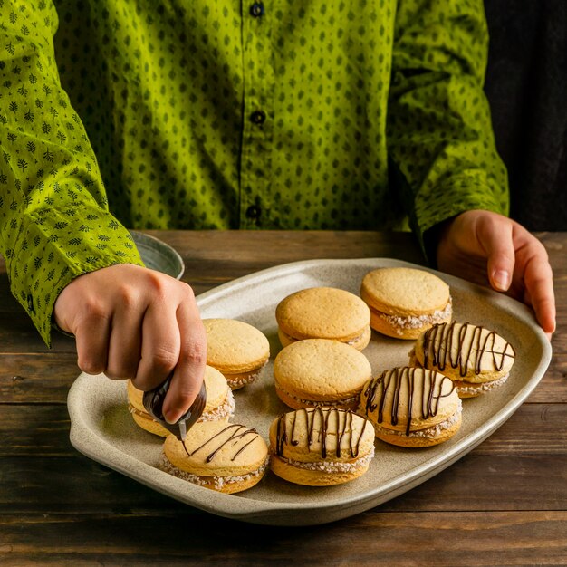 Cerrar la mano decorando galletas con crema