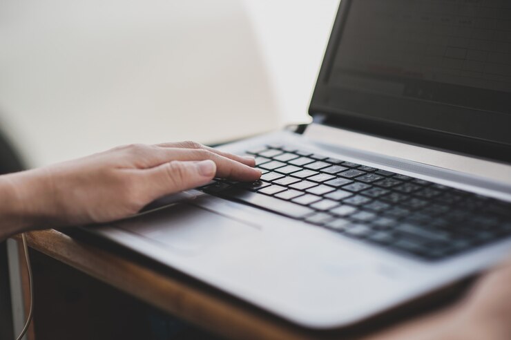 Foto cerrar mano escribiendo en el teclado de la computadora