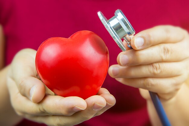 Foto cerrar la mano con estetoscopio está comprobando un corazón.