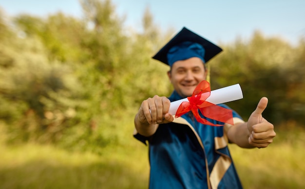 Cerrar la mano del graduado levantó las manos y celebró con un certificado en las manos y se sintió tan feliz en el día de la graduación, el concepto de éxito de la educación