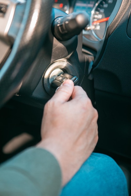 Foto cerrar la mano del hombre poner la llave para arrancar el espacio de copia del motor del automóvil